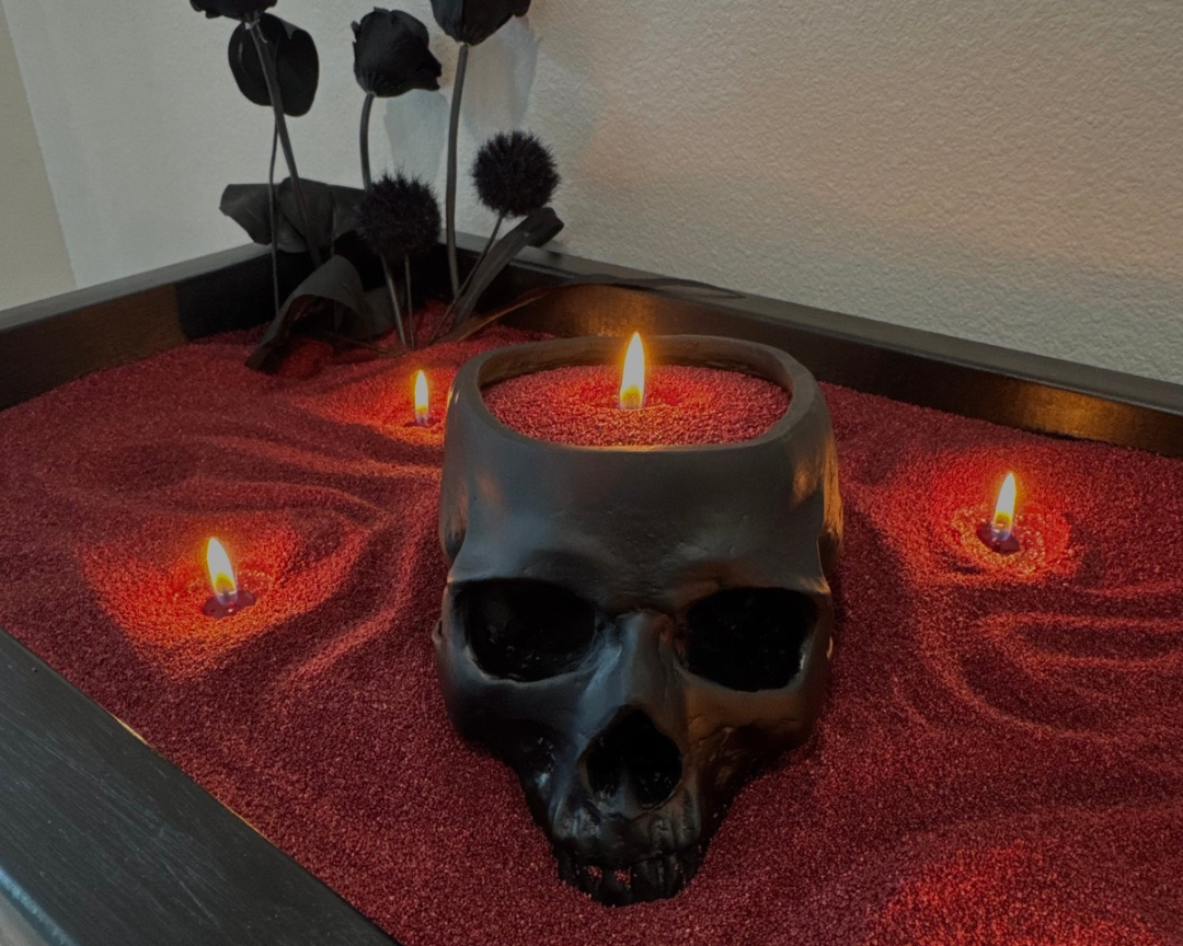 Gothic Halloween centerpiece with maroon Foton Pearled Candles, a black skull candle, and black roses in a decorative tray.