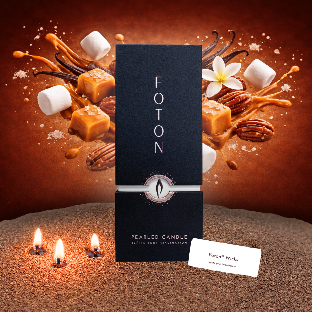 Black 18oz Foton Pearled Candle box set against a rich caramel-toned background with floating caramel cubes, vanilla pods, pecans, marshmallows, and a white flower, with three small flames glowing in wax pearls in the foreground.