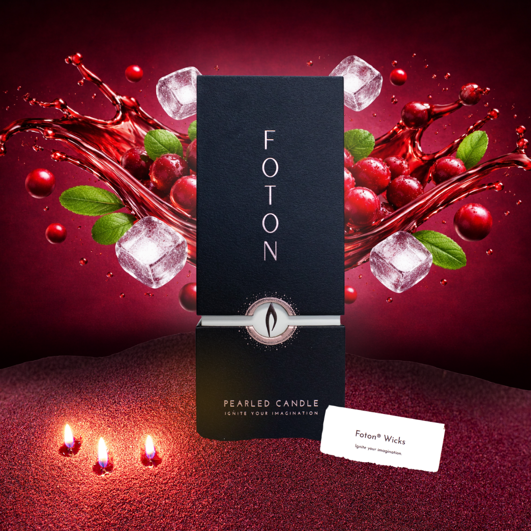 Black Foton Pearled Candle 18oz box centered against a vibrant red backdrop with splashing cranberry juice, fresh cranberries, mint leaves, and ice cubes, with three small candle flames glowing in red wax pearls in the foreground.