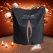 Black Foton Pearled Candle grande bag displayed against a warm caramel-themed backdrop with caramel splashes, vanilla pods, pecans, marshmallows, and soft glowing candle flames, with cotton wicks placed in front.