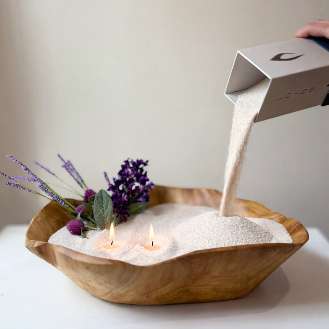 Lifestyle image showing Malibu Mama candle being poured into a handcrafted wood bowl, styled with florals for a warm, elevated ambiance.