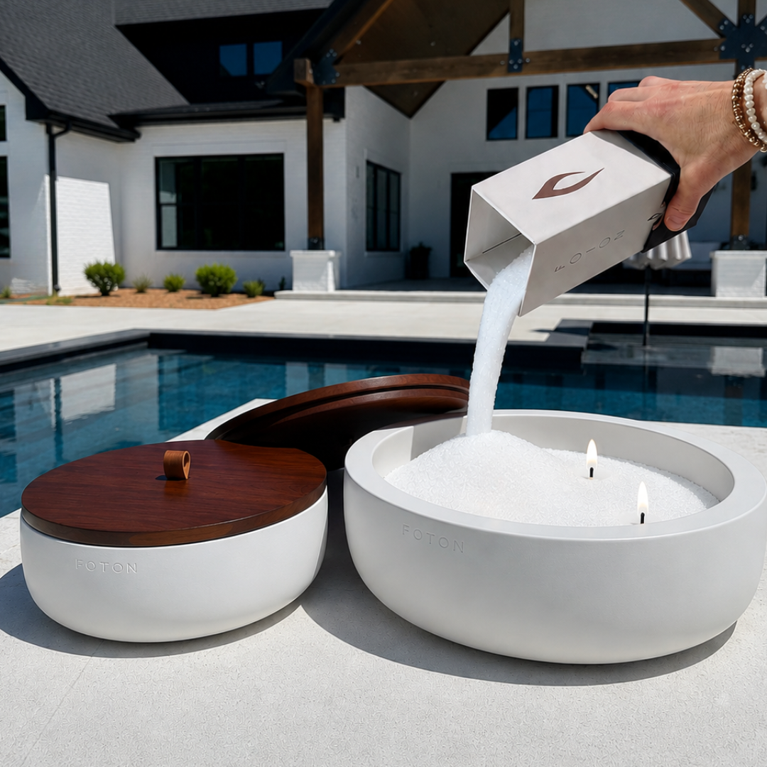 White Luxe Concrete Bowl being refilled with Foton Candle pearls beside a swimming pool. The image demonstrates the easy refill process and the reusable design of the concrete candle vessel.