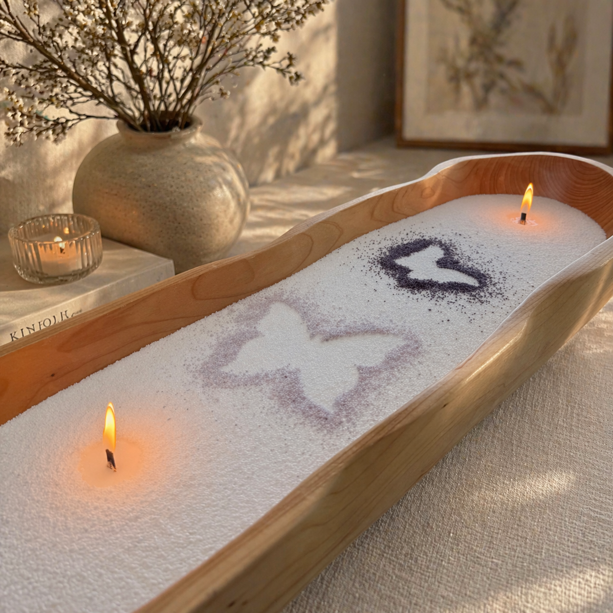 A warm, artistic lifestyle scene featuring a long wooden dough bowl filled with pearled candle wax, softly illuminated by two glowing flames. Subtle butterfly stencil designs add a personalized, decorative touch, while the surrounding natural textures and golden light create a cozy, handcrafted ambiance that highlights creativity and customization.