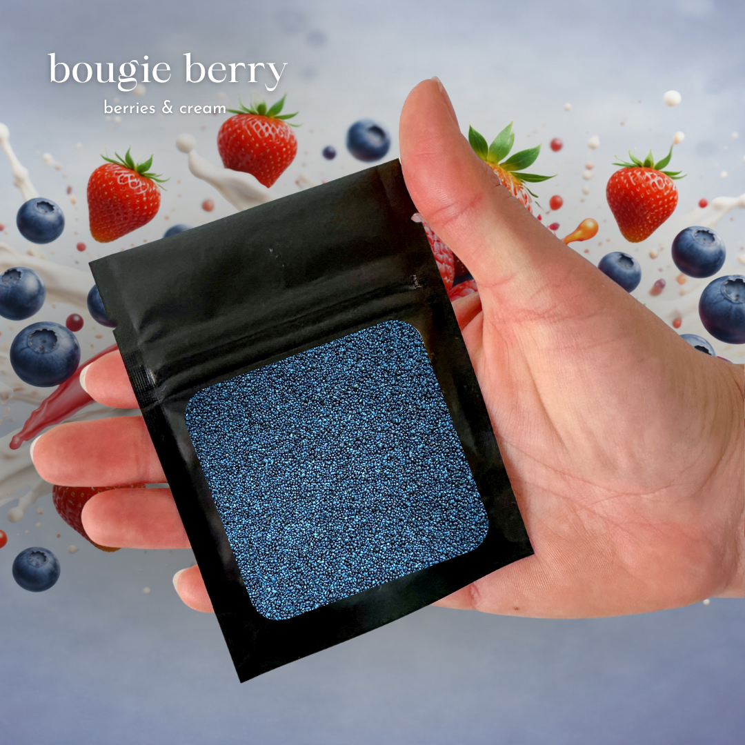 Product-focused image showcasing a Foton scent sample in “Bougie Berry – Berries & Cream,” featuring pearled wax in a compact packet held in hand, with vibrant berry visuals in the background to highlight the fragrance profile and a playful, sensory-driven experience.