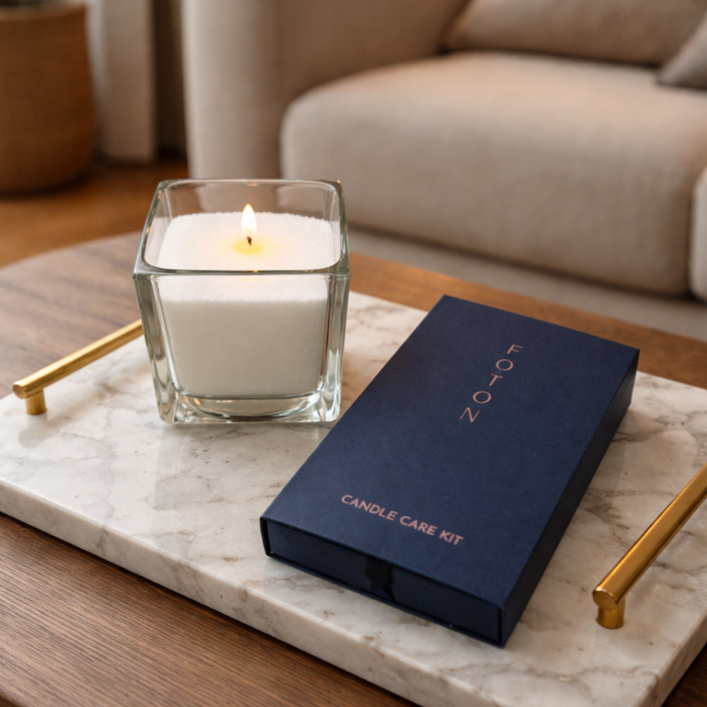 Lifestyle product image featuring a Foton pearled candle in a clear glass vessel paired with a premium candle care kit, styled on a marble tray with gold accents, highlighting a clean, modern aesthetic and emphasizing candle maintenance, longevity, and elevated everyday living.
