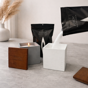 Product image showcasing the Foton pearled candle system, featuring refillable square vessels with wooden lids and premium pearled wax being poured from branded packaging, highlighting the clean, mess-free refill process, reusability, and modern, minimalist design.