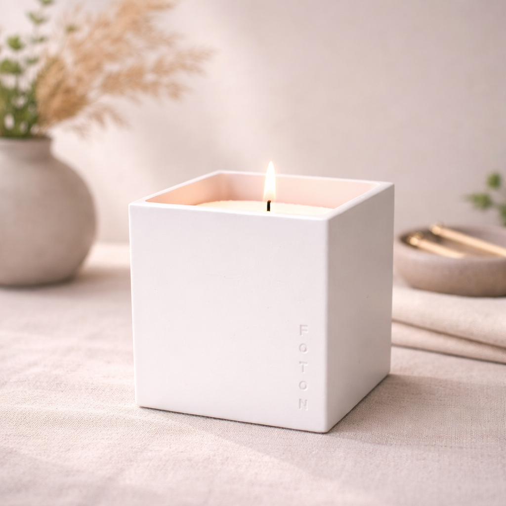 Lifestyle image of the Le Cube concrete candle in a white finish, styled on a clean, neutral décor and greenery, creating a calm, modern, and elevated home ambiance.